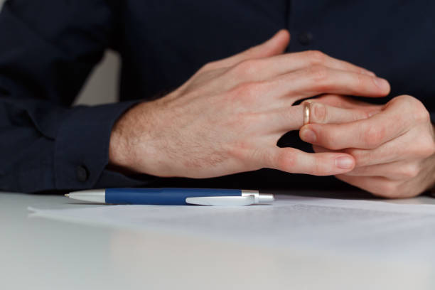 istock Young man is taking off the wedding ring. Close up view. Divorce concept 1199103035