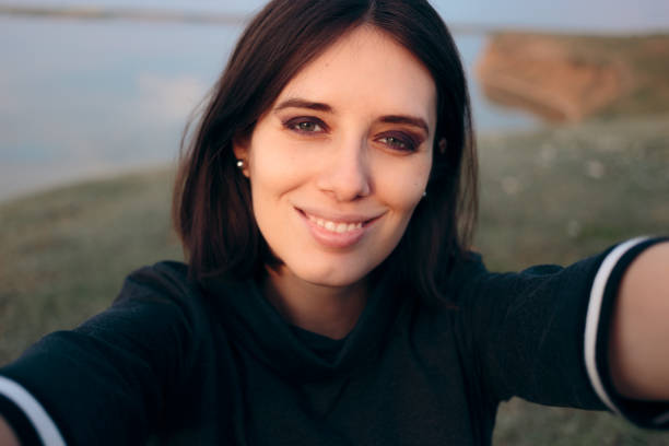 istock Cheerful Woman Taking a Selfie in Nature 1199106242