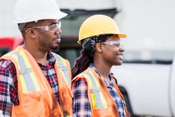 istock Female construction worker and coworker wearing hardhats 1199107650