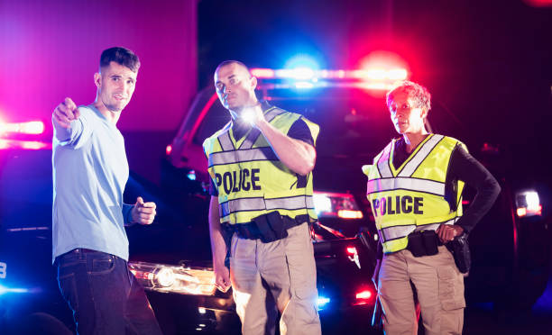 istock Police officers at night talking with young man 1199110011