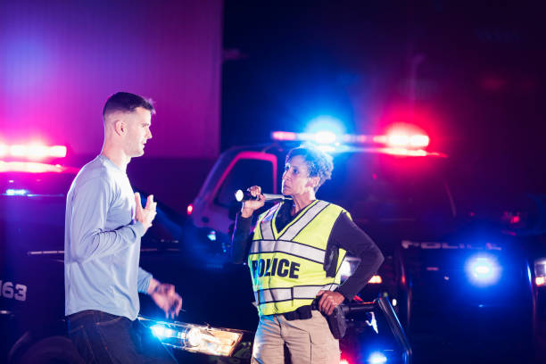 istock Policewoman at night talking with young man 1199110628