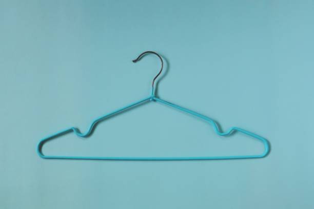 istock Clothes hangers on blue background for household items. 1199125944