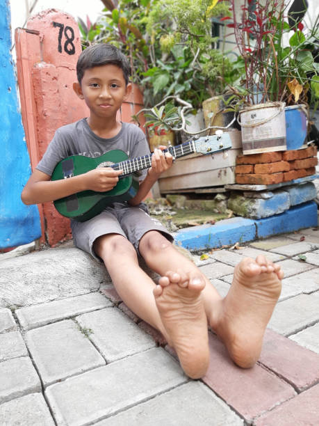istock A Young Indonesian Boy Plays His Mandolin. 1199126073