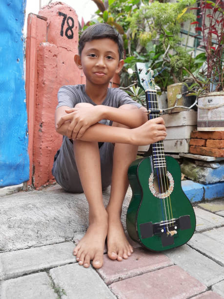 istock A Young Indonesian Boy Plays His Mandolin. 1199126074