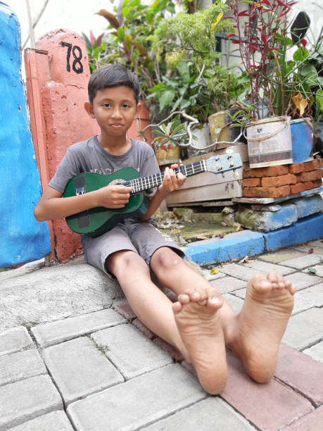 istock A Young Indonesian Boy Plays His Mandolin. 1199126079