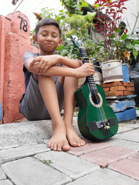 istock A Young Indonesian Boy Plays His Mandolin. 1199126087