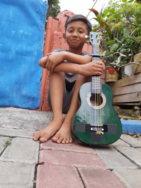 istock A Young Indonesian Boy Plays His Mandolin. 1199126091