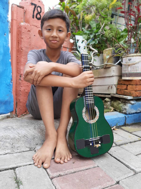 istock A Young Indonesian Boy Plays His Mandolin. 1199126093