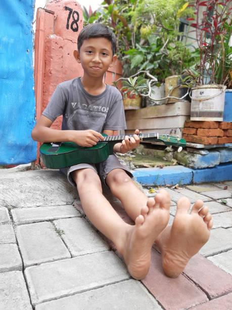 istock A Young Indonesian Boy Plays His Mandolin. 1199126094