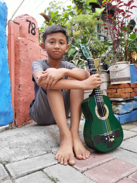 istock A Young Indonesian Boy Plays His Mandolin. 1199126100