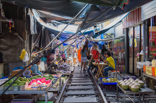 Maeklong,Thailand - Oct 31,2019 : Tourists can seen exploring and shopping along the Maeklong Railway Market.It is a Thai market selling fresh vegetables,food, fruit,as well as souvenirs and clothing.