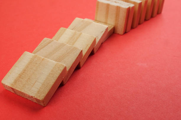 istock Domino effect isolated on red background. Selective focus 1199127304