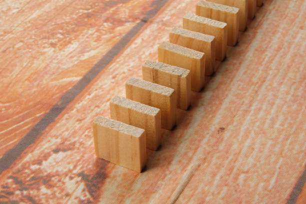 istock Domino effect isolated on wooden background 1199127345