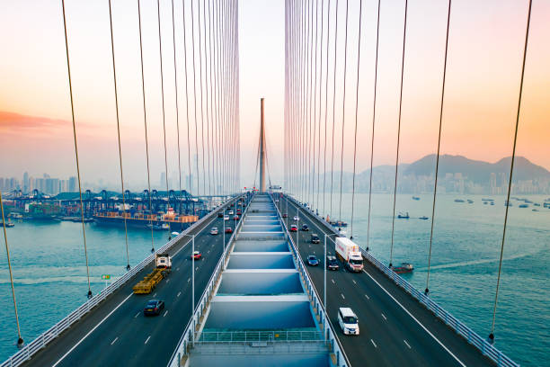 drohnenansicht der stonecutters bridge und des tsing sha highway bei sonnenuntergang - architecture bridge built structure business stock-fotos und bilder