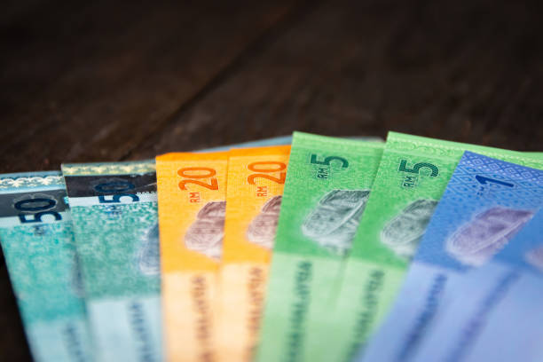 istock Various type of Malaysia Currency (MYR): Stack of Ringgit Malaysia bank note on dark brown a wooden table background. (There are one, five, twenty and fifty) 1199142491