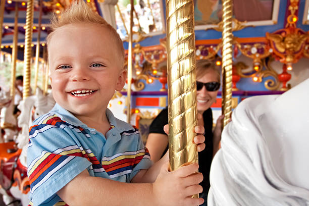 ребенок весело на carousel - аттракцион карусель стоковые фото и изображения