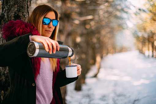 Cute Woman Drinking Coffee in Snowy Forest