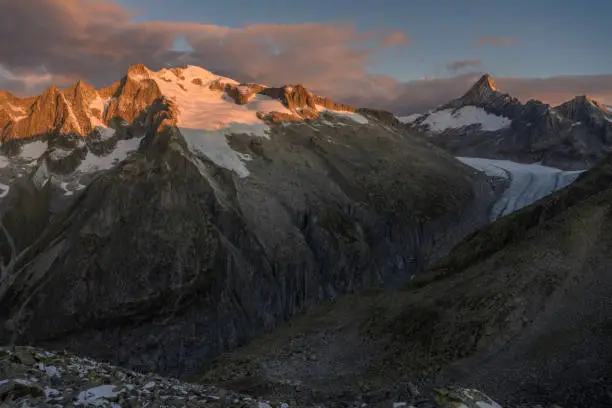 The mountain peaks of the Wannenhorn (left) and the mountain Finsteraarhorn (right) over the Fiescher glacier (German: Fieschergletscher) at sunrise. The Fiescher glacier is the third largest glacier in the European Alps and is located in Switzerland.