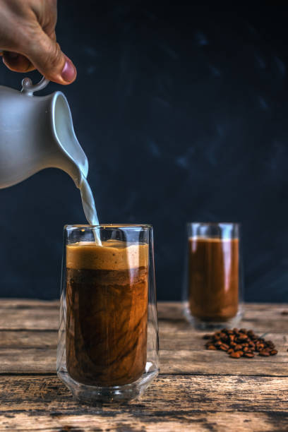 istock Cold coffee with ice and milk on a wooden table 1199151996