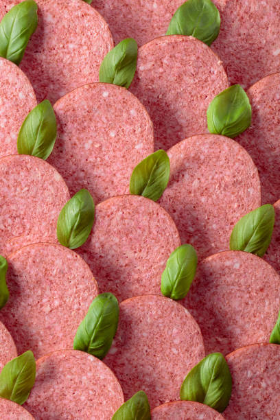 istock Sliced smoked sausage with green basil leaves. 1199152564