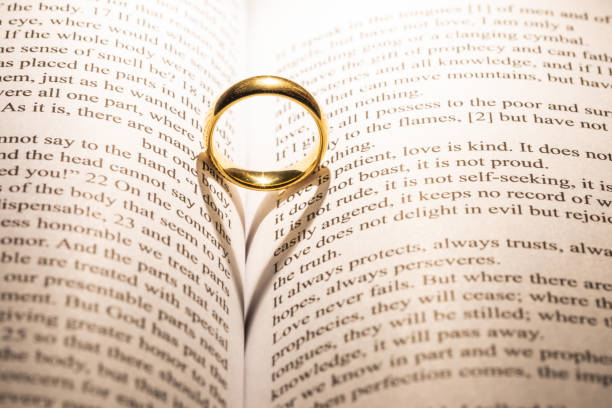 istock Golden wedding ring on bible book 1199158102