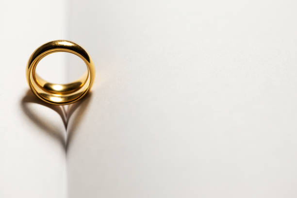 istock Golden wedding rings on book 1199158111