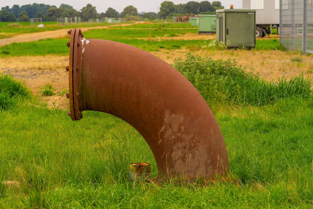 rust pipe of industry on green meadow. - rust metal imagens e fotografias de stock