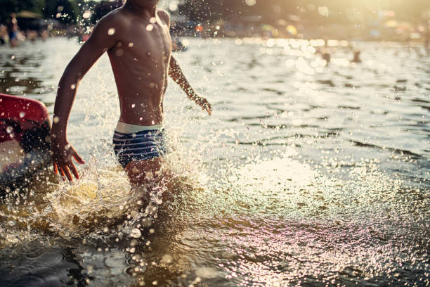 istock Little boy playing in lake 1199161705