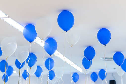 Blue and white color balloons in the room prepared for birthday party.