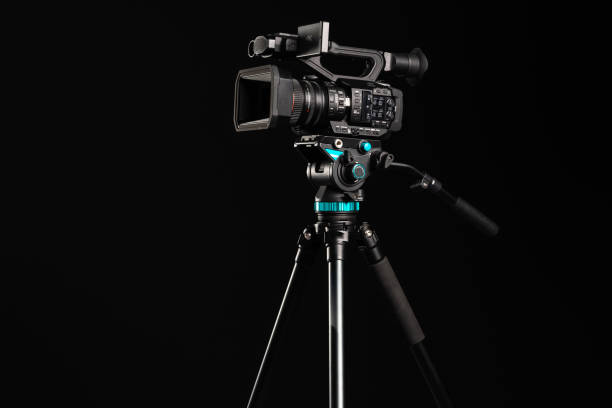 istock Professional 4K video camera on camera tripod on black background 1199165656