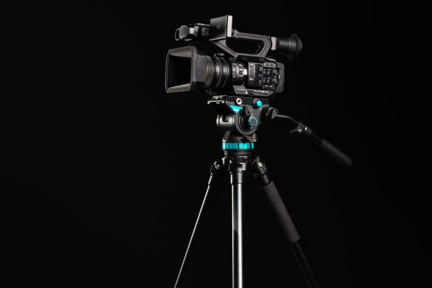 professional 4k video camera on camera tripod on black background - television camera tripod media equipment videography imagens e fotografias de stock