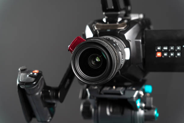 istock Professional video cinema camera on a camera tripod on black studio background copy space - close-up 1199165681