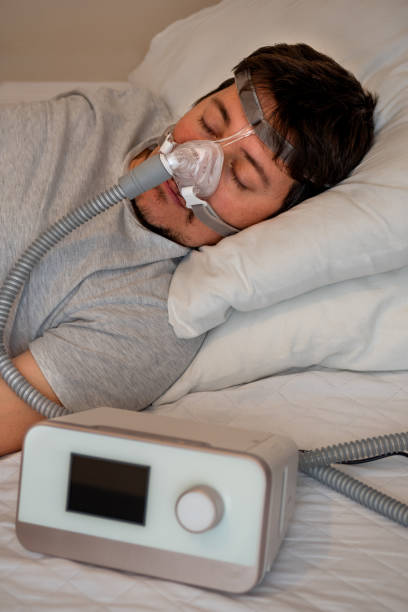 istock young man wearing ( CPAP Mask ) nasal mask and using CPAP machine for sleeping smoothly all night 1199166403