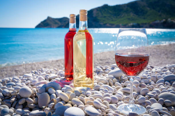 istock Red wine and wine glass on the beach 1199166747