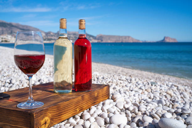 istock Red wine and wine glass on the beach 1199166774