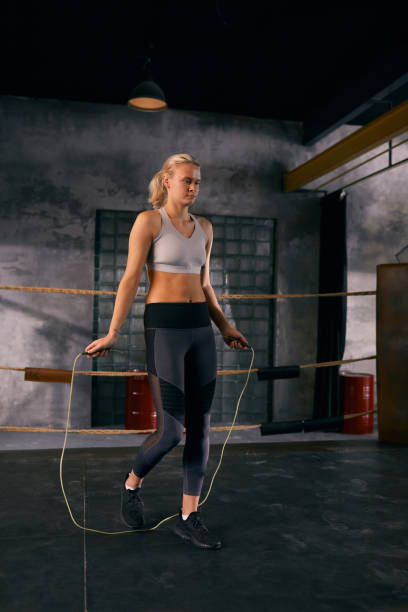 istock Young woman doing jumping rope warming up exercise before boxing on squared ring 1199167101