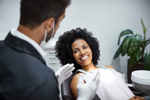 istock Dentist explaining smiling woman in clinic 1199167278