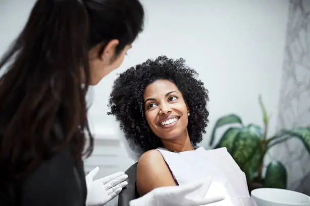 Photo of Dentist discussing with smiling female patient