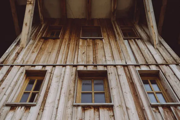 an old wooden house with rustic wooden windows with a view from below
