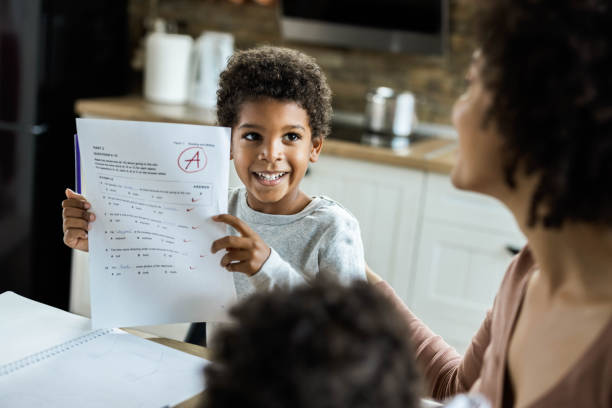 Look mommy, I've got an A on my test! Happy African American boy showing his family a positive results from an exam. report card stock pictures, royalty-free photos & images
