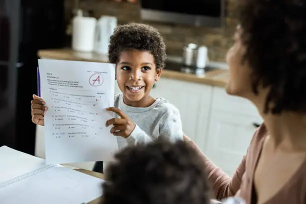 Happy African American boy showing his family a positive results from an exam.