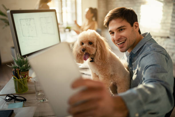 istock Happy entrepreneur using digital tablet while taking selfie with his poodle. 1199170070