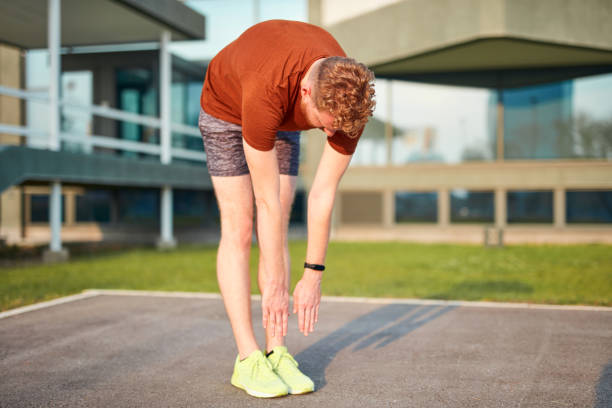 istock Young man exercising / stretching in urban park. 1199172101