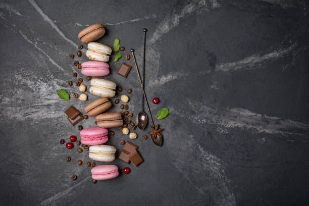 istock French dessert macaroons with coffee beans, nuts, chocolate and berries on black marble 1199172830