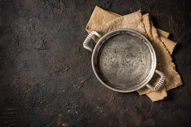 Top view of metall skillet for table setting on dark concrete background with copy space