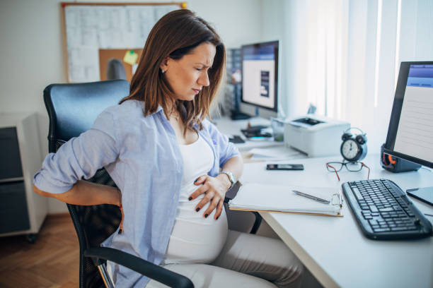 istock Pregnant lady working in pain in office 1199173959