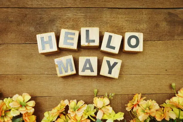 Photo of Hello May alphabet letters on wooden background