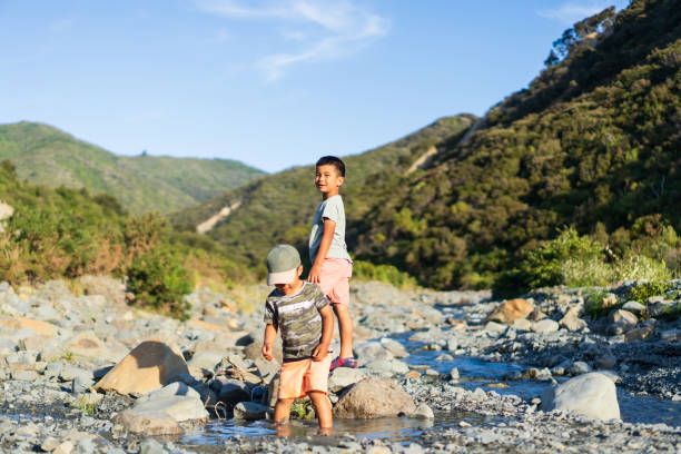 Kids outdoor having fun playing in a stream.