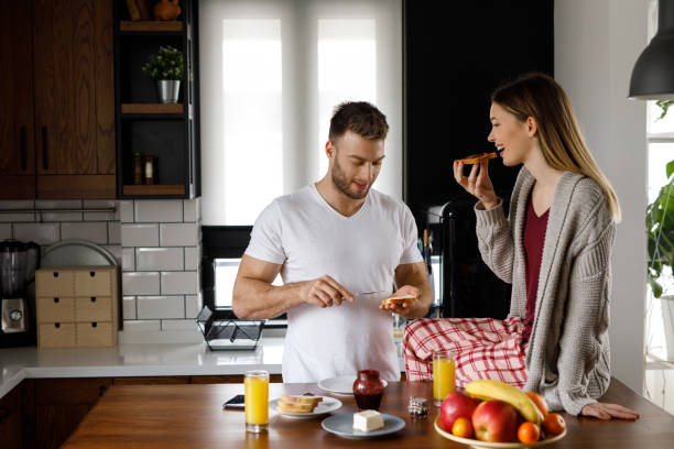 istock Young happy couple eating breakfast in the kitchen 1199175482
