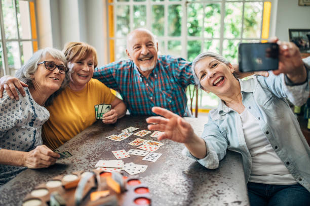 istock Old friends taking a selfie while playing cards 1199177974